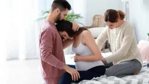 Doula and partner supporting pregnant woman